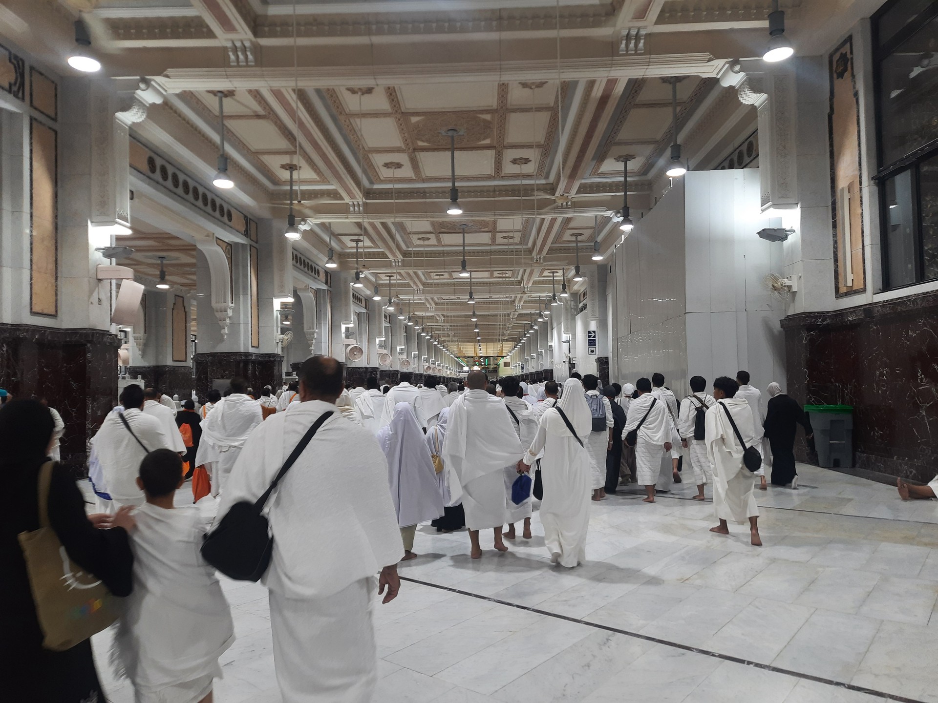 Umrah pilgrims and worshipers in the Kaaba, the Grand Mosque, Alharam mosque im Mecca, the most sacred place for Muslims, and millions of people visit it every year. Men wear white Ihram clothes